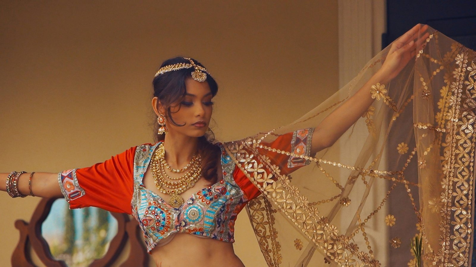 a woman in a belly dance outfit holding a piece of cloth
